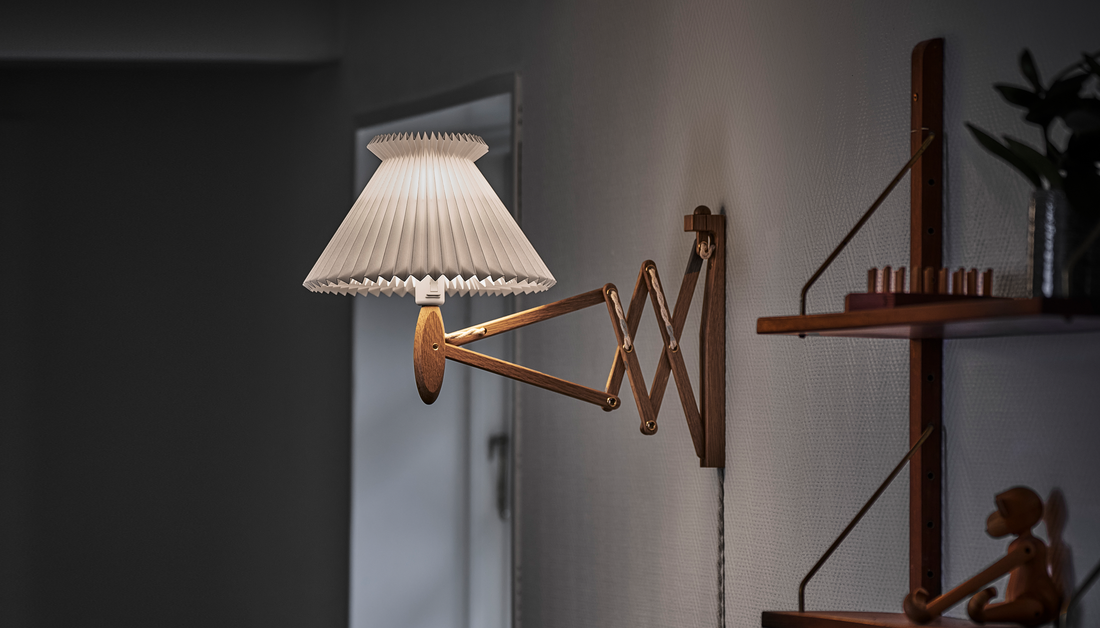 Sax lampen fra Le Klint ved siden af reol i stue